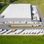 Loading bay, truck parking lot, industrial building, logistics – aerial view